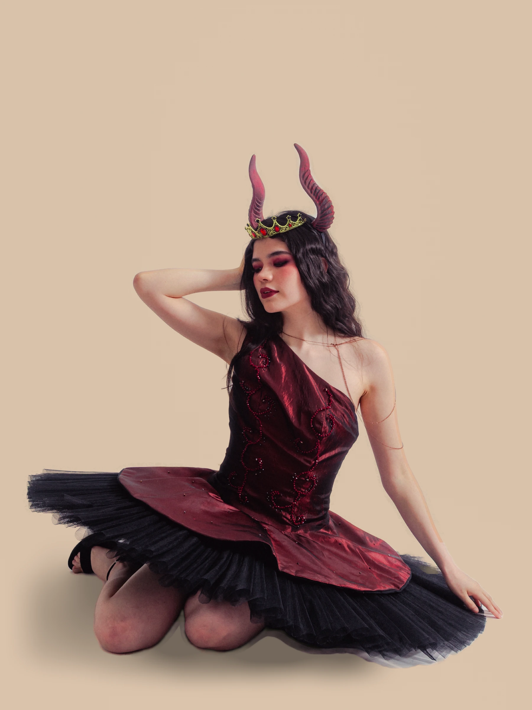 Diseño de Sofía Damhar Ramírez: corsé y falda en tonos burdeos y negro sobre fondo beige.