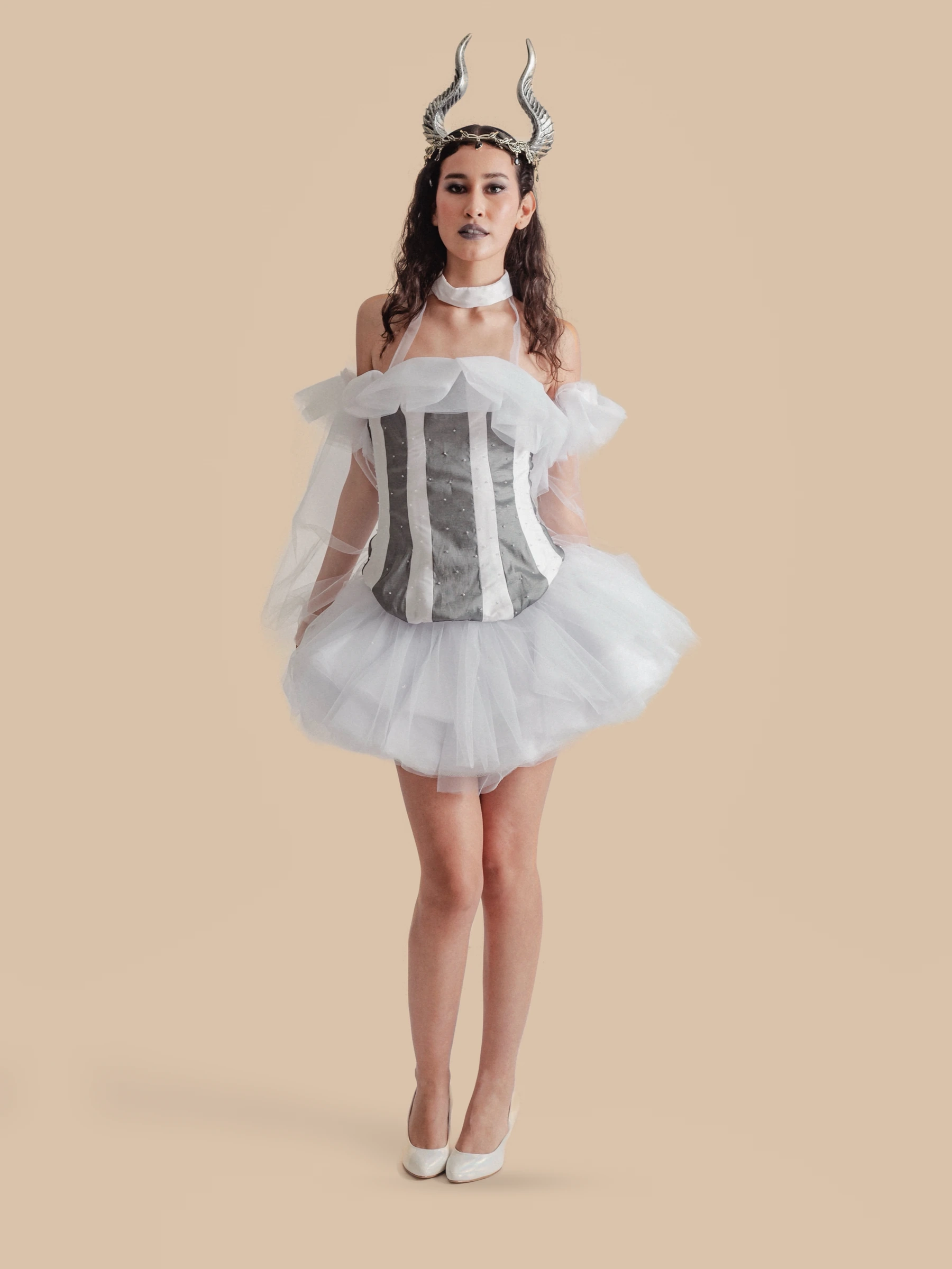 Diseño de Sofía Damhar Ramírez: corsé gris y blanco con falda de tul sobre fondo beige.