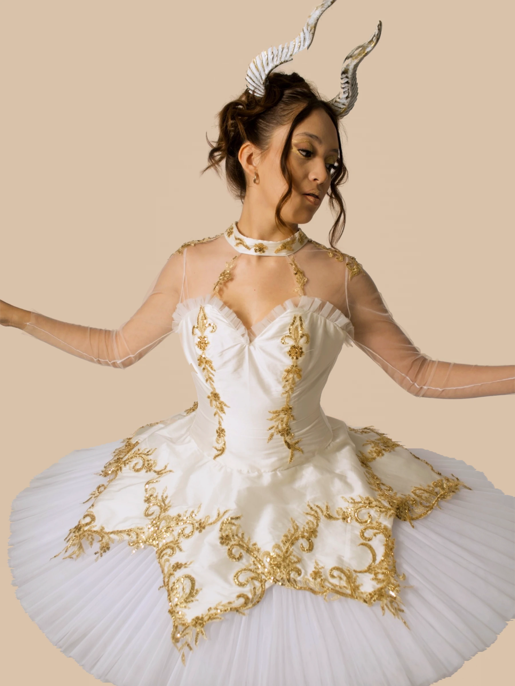 Diseño de Sofía Damhar Ramírez: vestido blanco con bordados dorados sobre fondo beige.