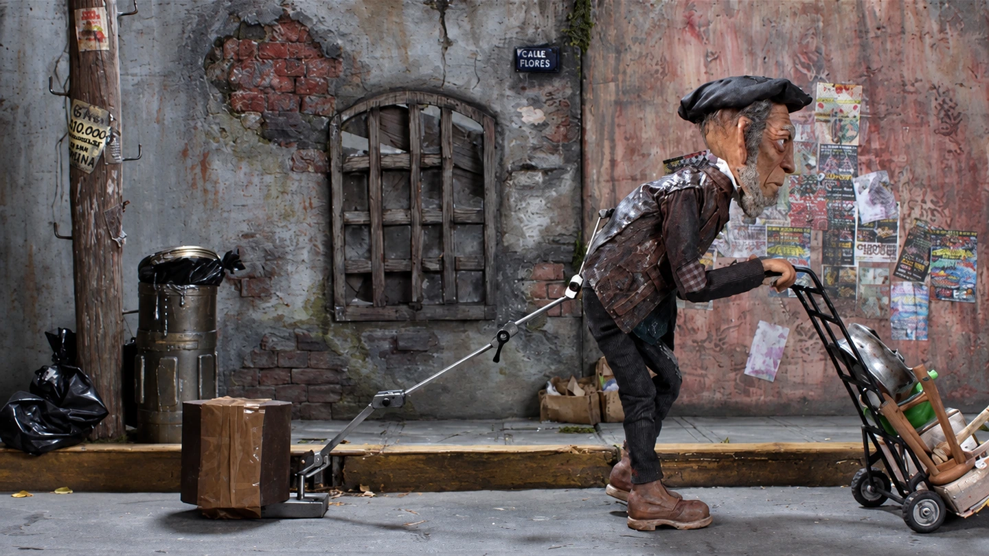 Personaje de stop motion transportando objetos en una carretilla.